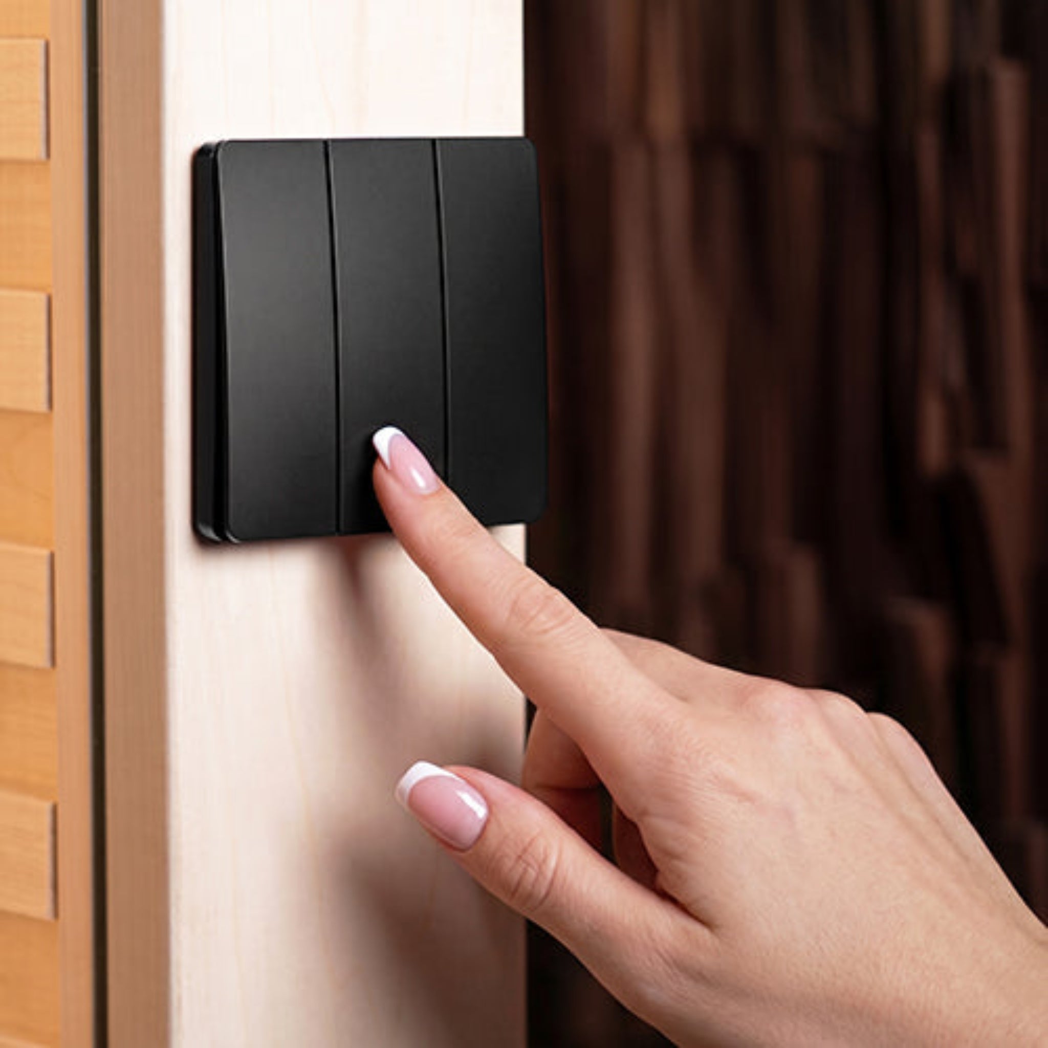 a hand pointing to a wall control for Prosaunas led light