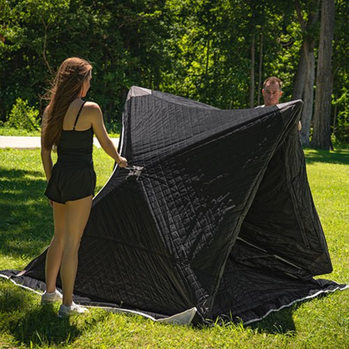 SaunaLife SaunaTrekker Portable Sauna Tent setup with a man and woman setting it up