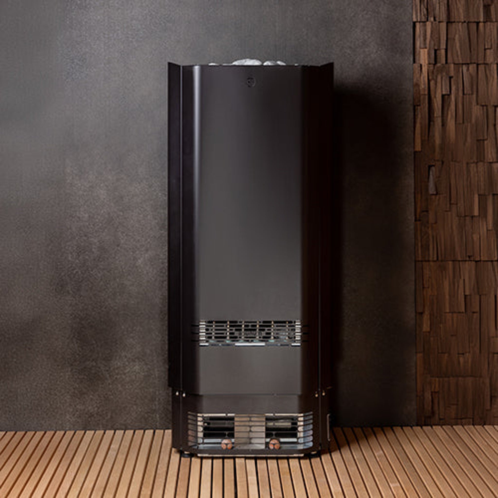 Saunum air perfect sauna heater in black against a dark wall with wooden floor.